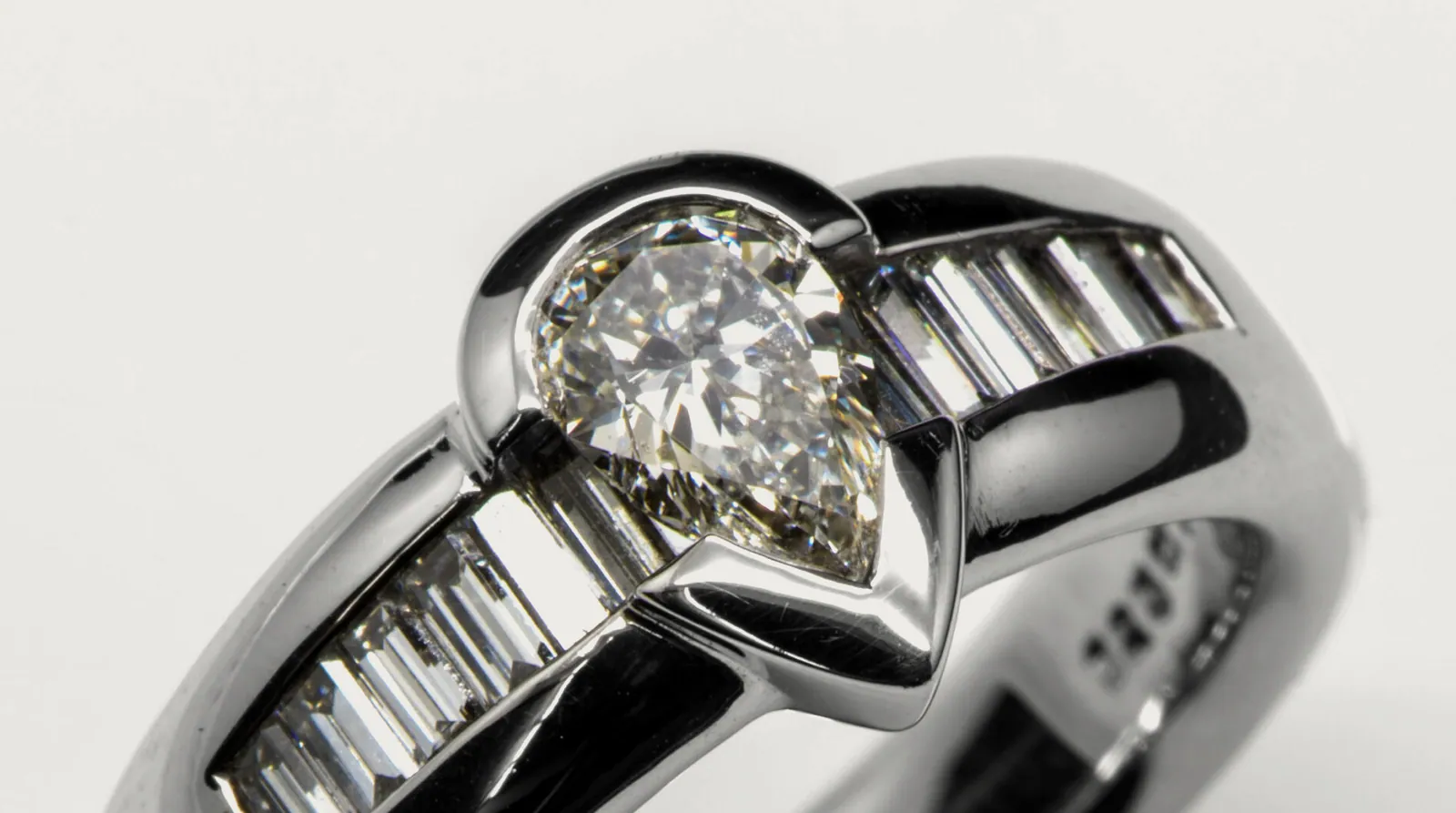 PearCut: PearCut-Diamant, getragen von Baguette-Diamanten in präziser Kanalfassung — zeitlose Eleganz in Weißgold.
